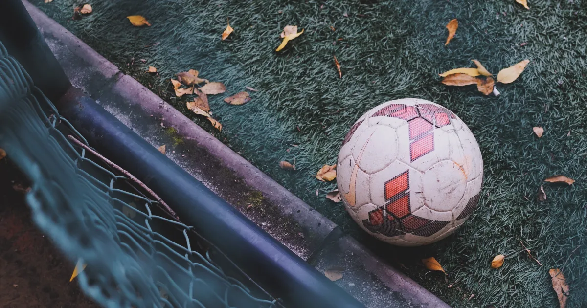 Ballon de football au bord d’un terrain parsemé de feuilles d’automne