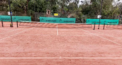 Campo da tennis in terra battuta visto dalla linea di fondo