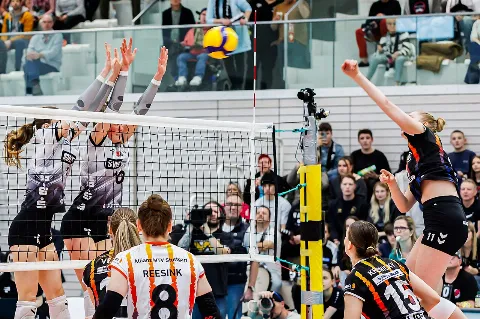 Giocatrici di pallavolo impegnate a rete in palestra